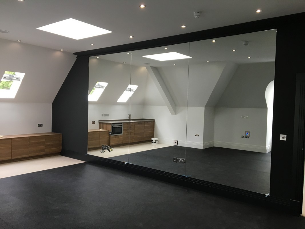 Frameless glass wall dividing loft conversion in Greenwich
